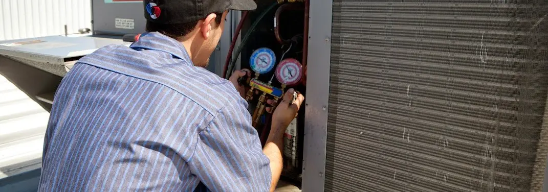 HVAC technician servicing a condenser unit in Brown Deer